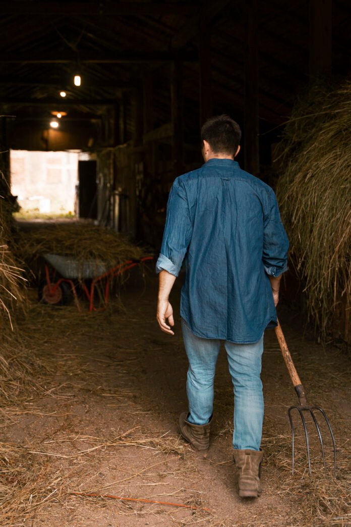 man-working-with-pitchfork-back-view