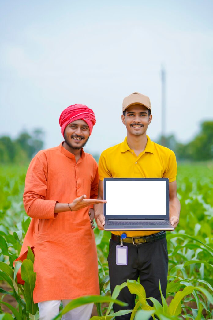 Young indian banker or agronomist showing laptop screen with far